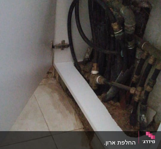 ארון פתוח עם צינורות ומחברים מתכתיים
